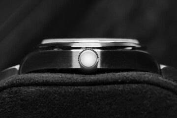 A detailed black and white view of a luxury wristwatch crown