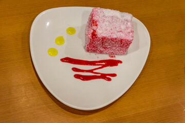 Piece of pink cake Pasta Roza on wooden table