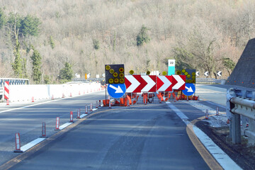 Many road signals and big arrows during roadworks in the motorway