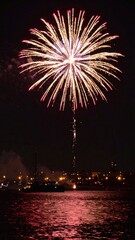 Fireworks display over city water.