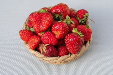 Fresh organic strawberries with natural blemishes in a wicker basket