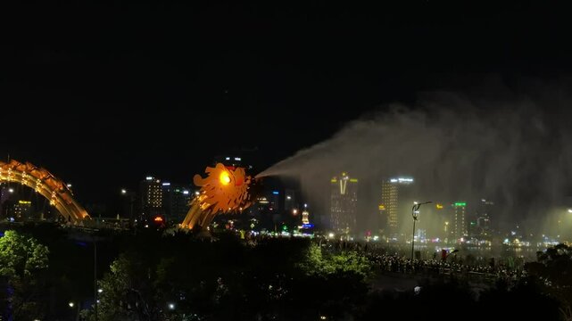 Dragon bridge illuminating da nang's nightscape, breathing fire against dark sky, spanning han river with dramatic lighting and bustling urban energy
