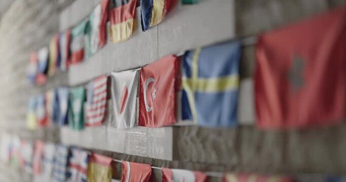 Colorful arrangement of international flags displayed on a textured wall
