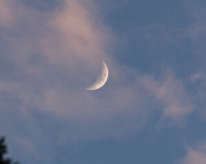 crescent moon at sunset with clouds