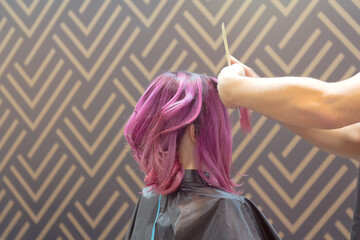 Hairdresser makes hairstyle woman vividly colored hair