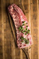 Fresh baby back pork ribs on a cutting board in a kitchen ready for grilling