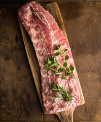 Fresh baby back pork ribs on a cutting board in a kitchen ready for grilling