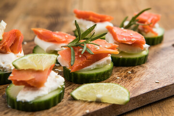 Appetizer canape. Fresh cucumber slices topped with cream cheese and smoked salmon garnished with herbs