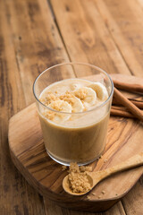 Almond butter smoothie bowl with granola in a coconut bowl, top view. Healthy vegan food concept