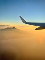 Airplane wing view at sunrise during flight