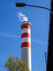 Red and White Smokestack Against Blue Sky