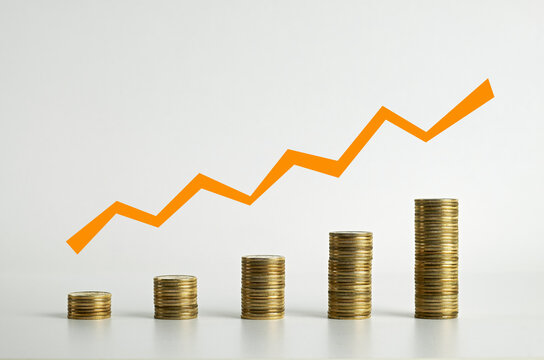 Coins arranged as a bar chart with a graph line above. Five stacks of coins with a graph line above - stock photo.
