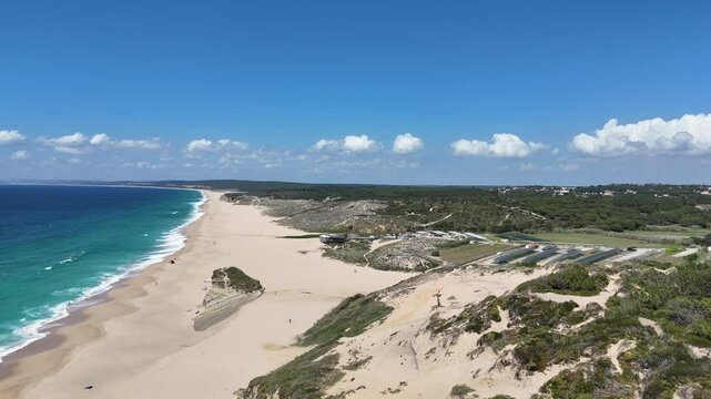Cinematic drone flyover from grassy dunes and beach parasols to Irm&atilde;o restaurant on Caparica beach, near Lisbon. Warm light, natural textures and elegant travel atmosphere by the ocean.

