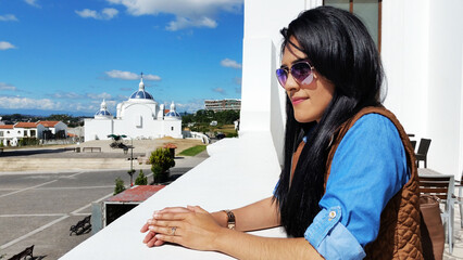 Mujer bonita de pie admirando la vista desde un balcón durante su viaje de vacaciones. Fotografía hecha con el teléfono móvil.