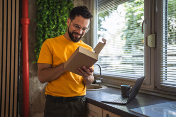 Delight happy caucasian man with package in the kitchen