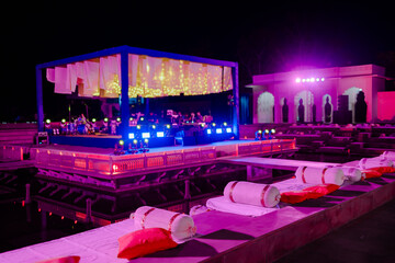 Event stage and seating bathed in purple light, creating a festive atmosphere. Concert on stage....