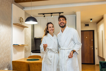 Couple in Bathrobes Admiring Hotel Room Interior