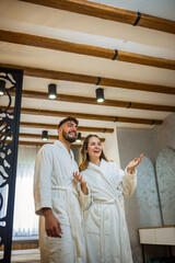 Couple in Bathrobes Admiring Hotel Room Interior