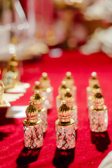 Elegant Perfume Bottles: A symmetrical arrangement of ornate gold-topped perfume bottles on a vibrant red surface exudes luxury and sophistication.