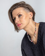 Portrait of smiling young woman close-up on grey background. Studio photography. Vertical photo. High quality photo