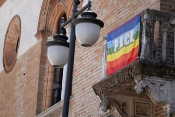 Rainbow Flag with Pace Text on Historic Balcony