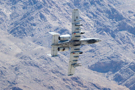 Bottom view of a A-10 Thunderbolt II in a turn against the Nevada hills