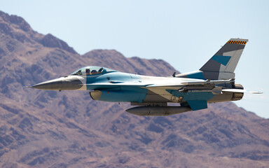 Side view of a F-16 Fighting Falcon  in the aggressor color scheme against the Nevada hills, with...