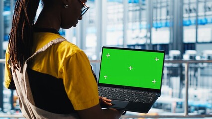 Smart factory specialist using mockup laptop to test automated systems and ensure reliability....