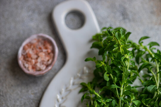 Overhead view of a bunch of wild mint and Himalayan salt on a ceramic board