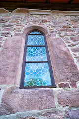 A very narrow window in the stone wall of the old castle