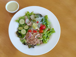 top view Tuna salad on a white plate and salad dressing in a cup on the table, food, vegetables, copy space