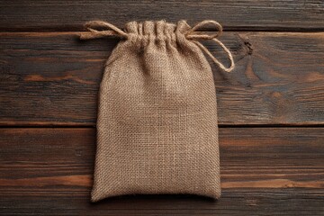 Burlap sack with tied string sits centered on dark rustic wooden planks