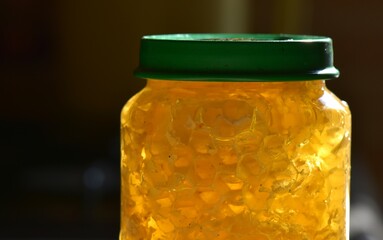 Honey in a glass jar with a green lid closeup