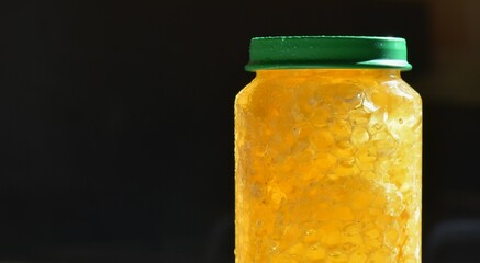 Honey in a glass jar with a green lid closeup