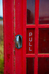 Red telephone booth over a brick wall. Old vintage english telephone booth on a cool background casting shadow.
