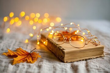 Cozy autumnal scene with book, glasses, and lights