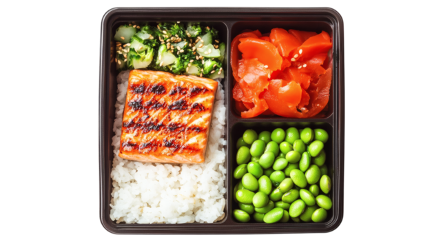 Japanese bento box with compartments holding rice, grilled salmon, pickled vegetables, and edamame isolated on white background 