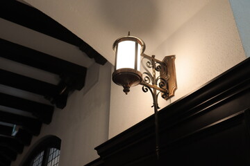 An old street lamp on an interior wall. Beautiful old lamps and decoration. Design for lighting and indoor architecture.	