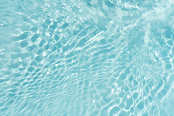 Blue water with ripples on the surface. Defocus blurred transparent blue colored clear calm water surface texture with splashes and bubbles. Water waves with shining pattern texture background.
