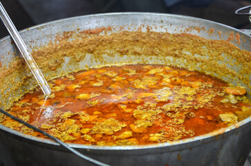 Сlose-up view of a giant metal pot containing a vibrant, Ukrainian borscht simmering over heat