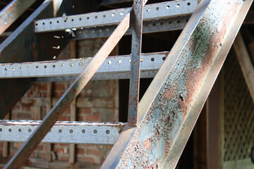 A close-up of a rusty and exterior stairs. Metal and old stairs. Construction industry and outdoor problem. Peeling paint on old metal stairs.