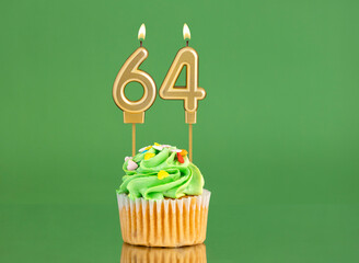 Number 64 birthday candle - Cupcake on a green background