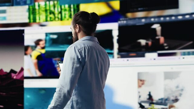 Young happy adult focused on online connection and scrolling on social pages, texting his friends and creating quality content for global reach. Trend setter guy on web design. Camera A.