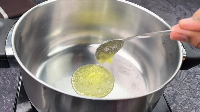 Teaspoon of Ghee Melting in Wide Pan for Traditional Indian Cooking, Healthy Fat Concept, Ayurvedic Cuisine Ingredient