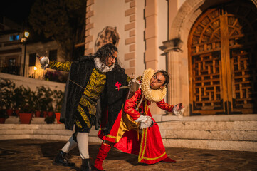 Spanish men in traditional colonial clothing dueling with swords called foils and daggers in a traditional 1600s town setting.