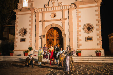 Group of actors dressed as characters from the Spanish colony of the 1600s in front of an old...