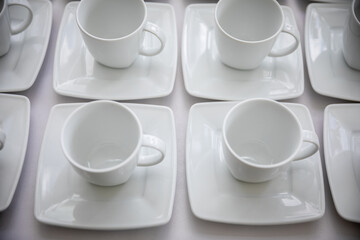 Chic and Elegant White Coffee Cups Set on Contemporary Square Plates for Modern Dining