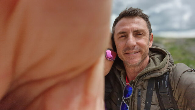 Funny couple selfie in which the husband covers the lens with his hand and as a result also almost the whole face of the wife