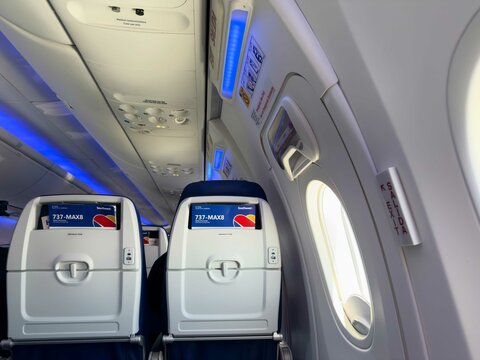 Southwest Airlines Boeing 737 MAX 8 airplane cabin interior focusing on the exit row seats, overhead panels, and emergency instructions - California, USA - June 10, 2025