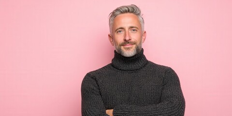 Confident Man in Sweater Posing Against a Pink Background